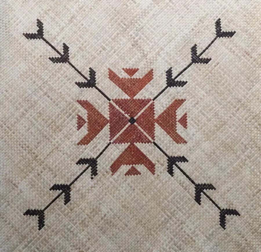 A woven mat with a red arrow design