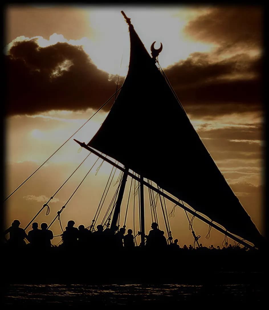 A waka sail in silhouette against the evening sky